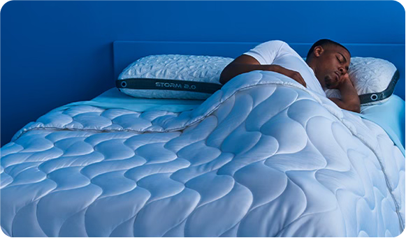 A man sleeping on comfortable bedding.