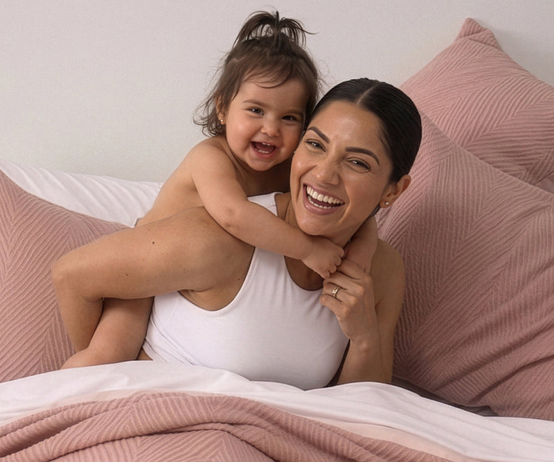 A happy woman with her child after learning about how better sleep improves longevity.