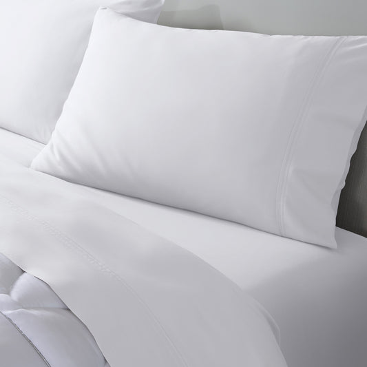 White bed sheets and two white pillowcases neatly arranged on a bed, showing a clean and crisp bedding set.