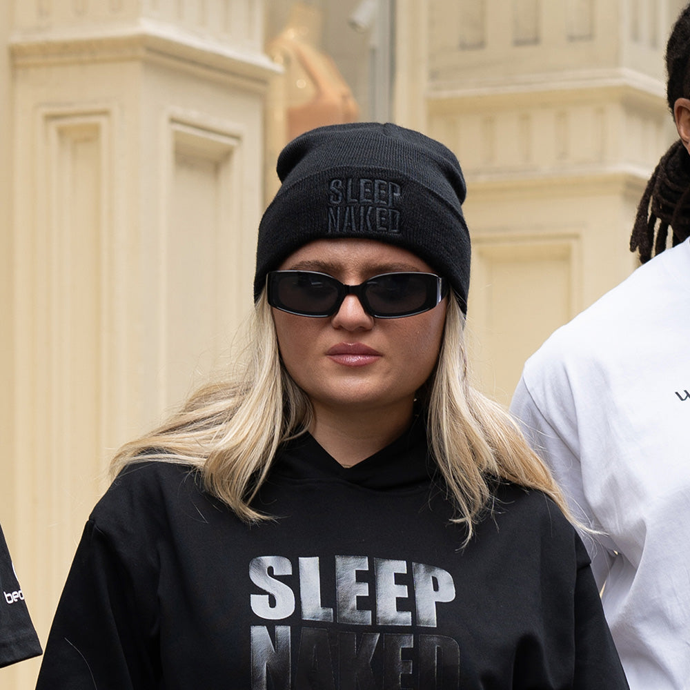 A woman wearing a Sleep Naked beanie.
