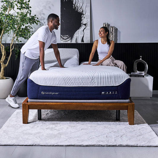 A happy couple testing out a split head mattress.