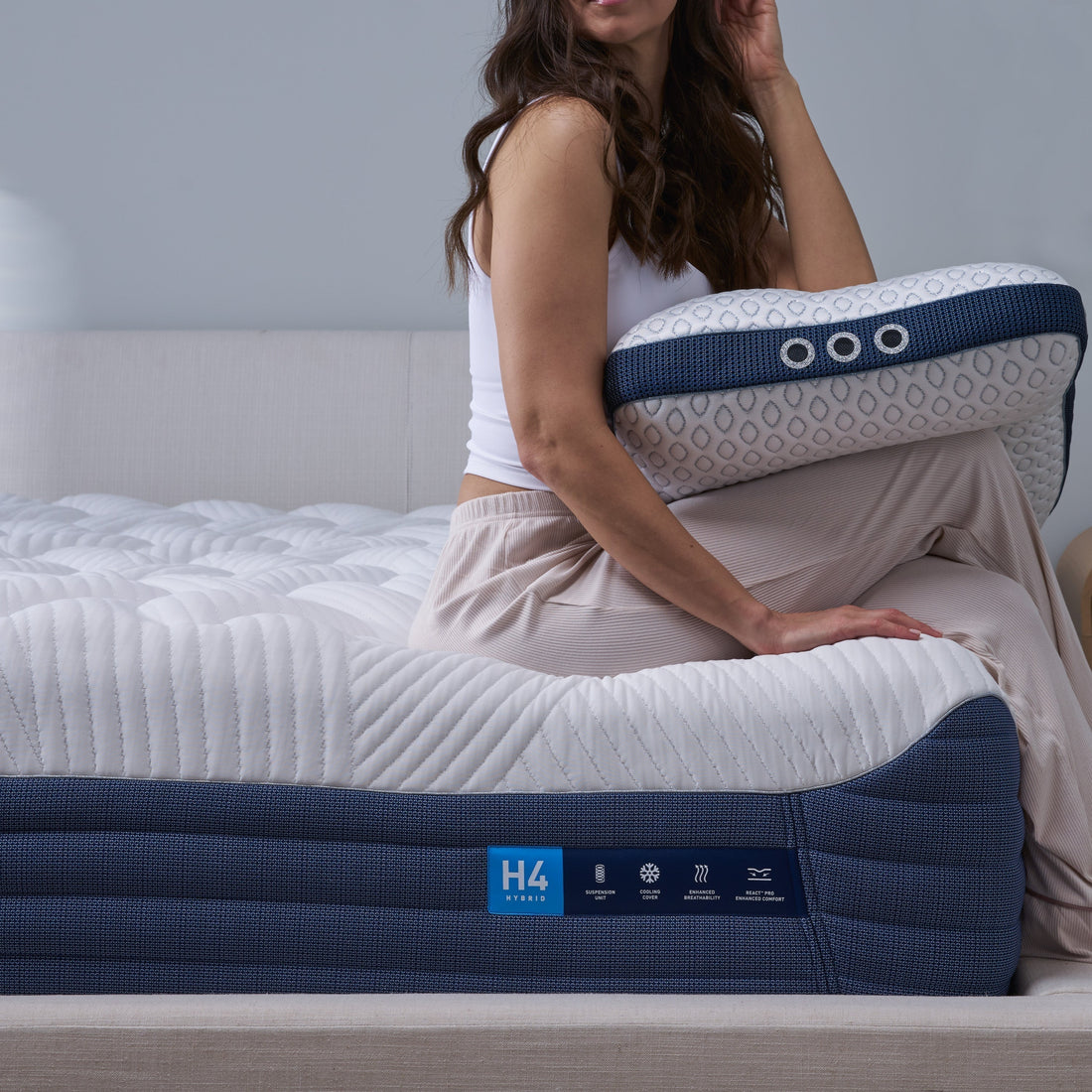 A woman sitting on a pillow top mattress. 
