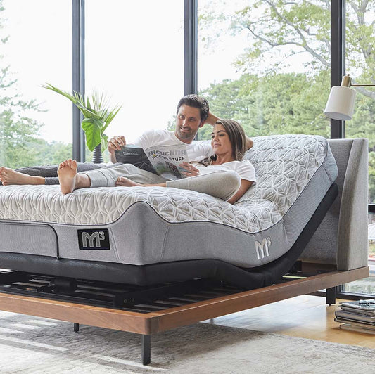 A couple reading on a Bluetooth bed frame.