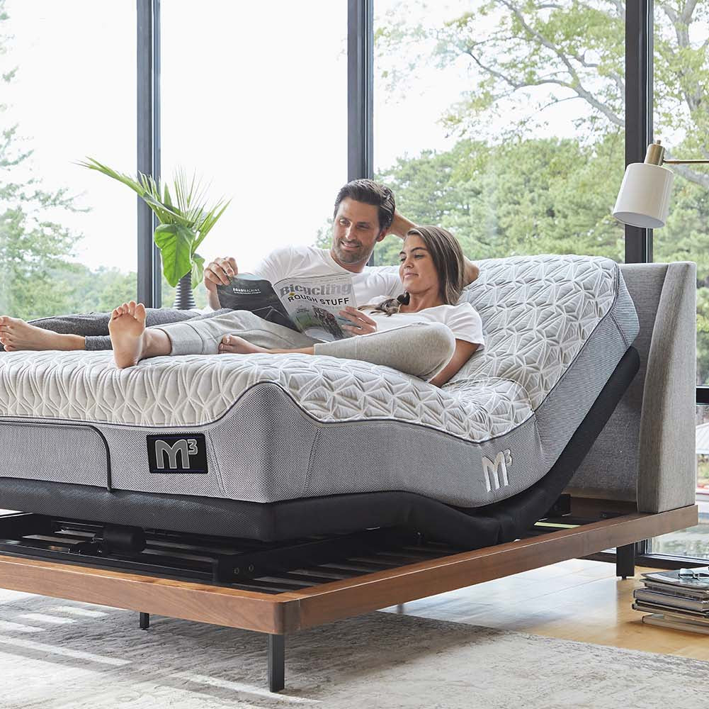 A couple reading on a Bluetooth bed frame.