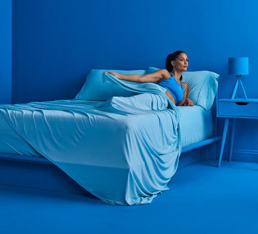 A woman sleeping in a bed with cooling sheets.