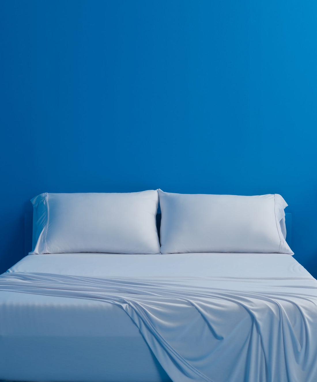 A photo of bed sheets on a bed with two pillows.