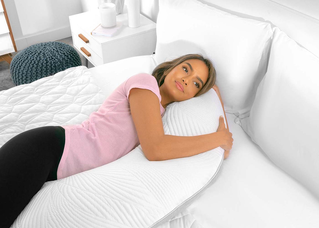 A woman sleeping after learning how to use a pregnancy pillow. 