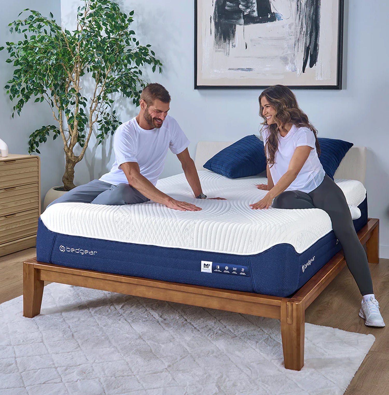 Man and woman sitting on an M3 mattress