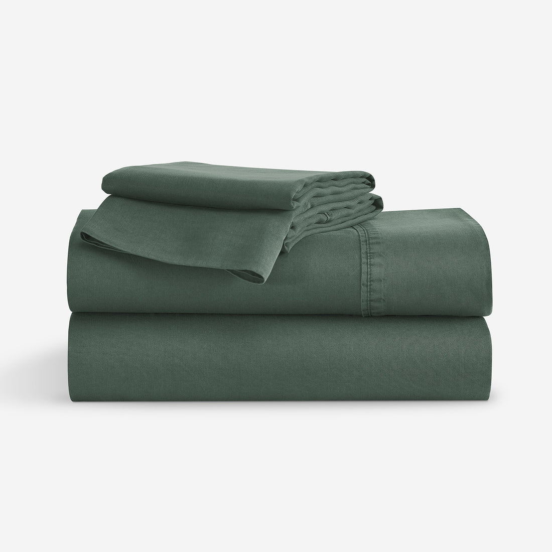 A stack of folded dark green bedding, including folded sheets  and a matching folded pillowcase, shown on a clean white background. "Moss"