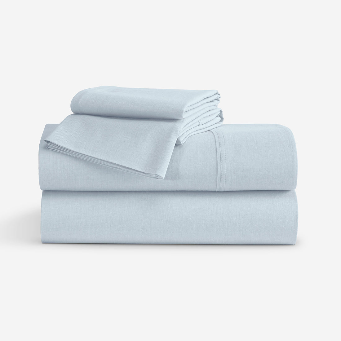 A stack of light blue folded bedding, including a folded sheets and matching pillowcases, photographed on a clean white studio background. "Light Blue"