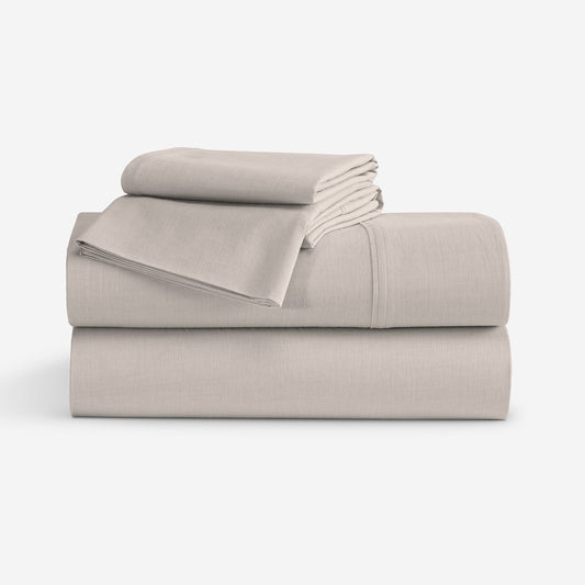 A stack of  folded sheets in a light taupe-beige color, displayed on a clean white background. "Taupe"