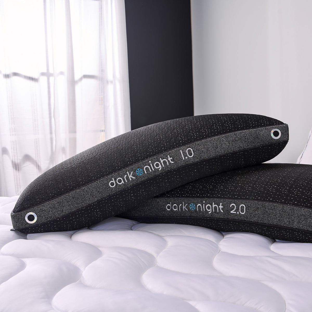 Two dark night pillows on a bed.