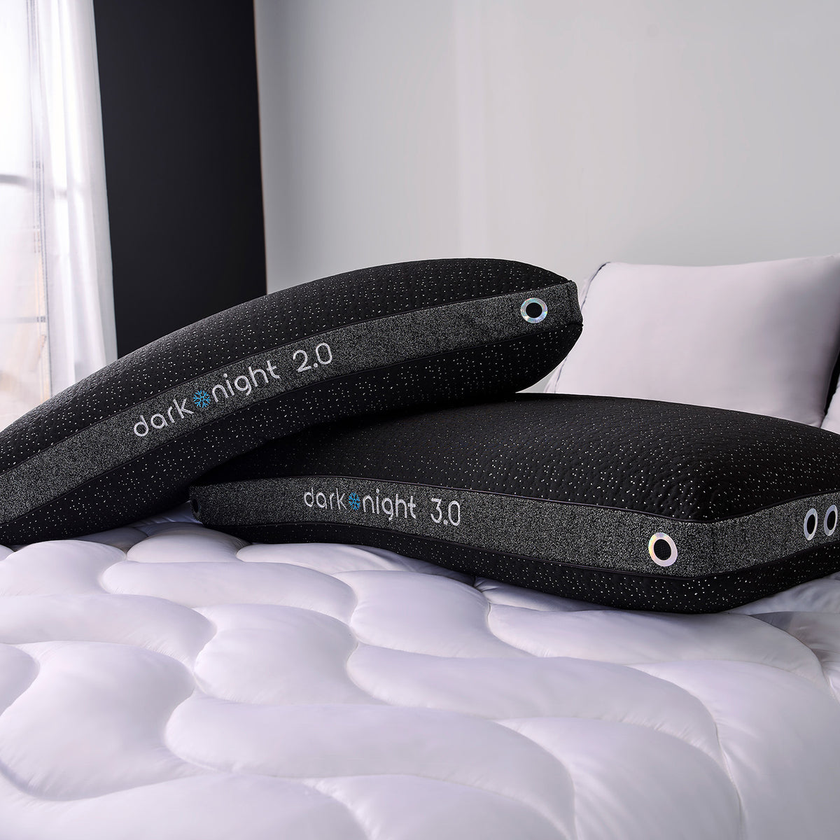 Two dark night king pillows on a bed.