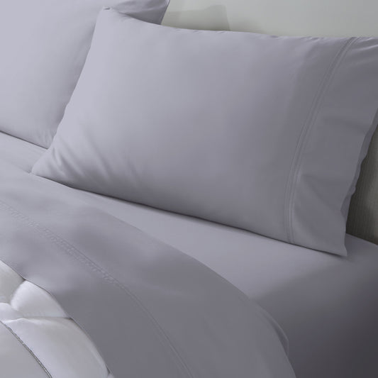 Light gray bedding set including a pillowcase and sheets on a bed. 
