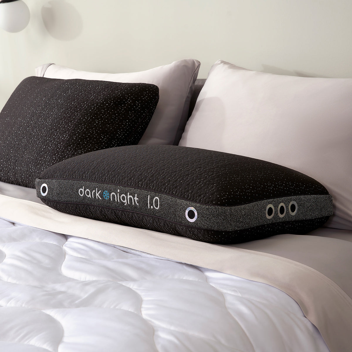 Two Dark Night pillows on a bed.