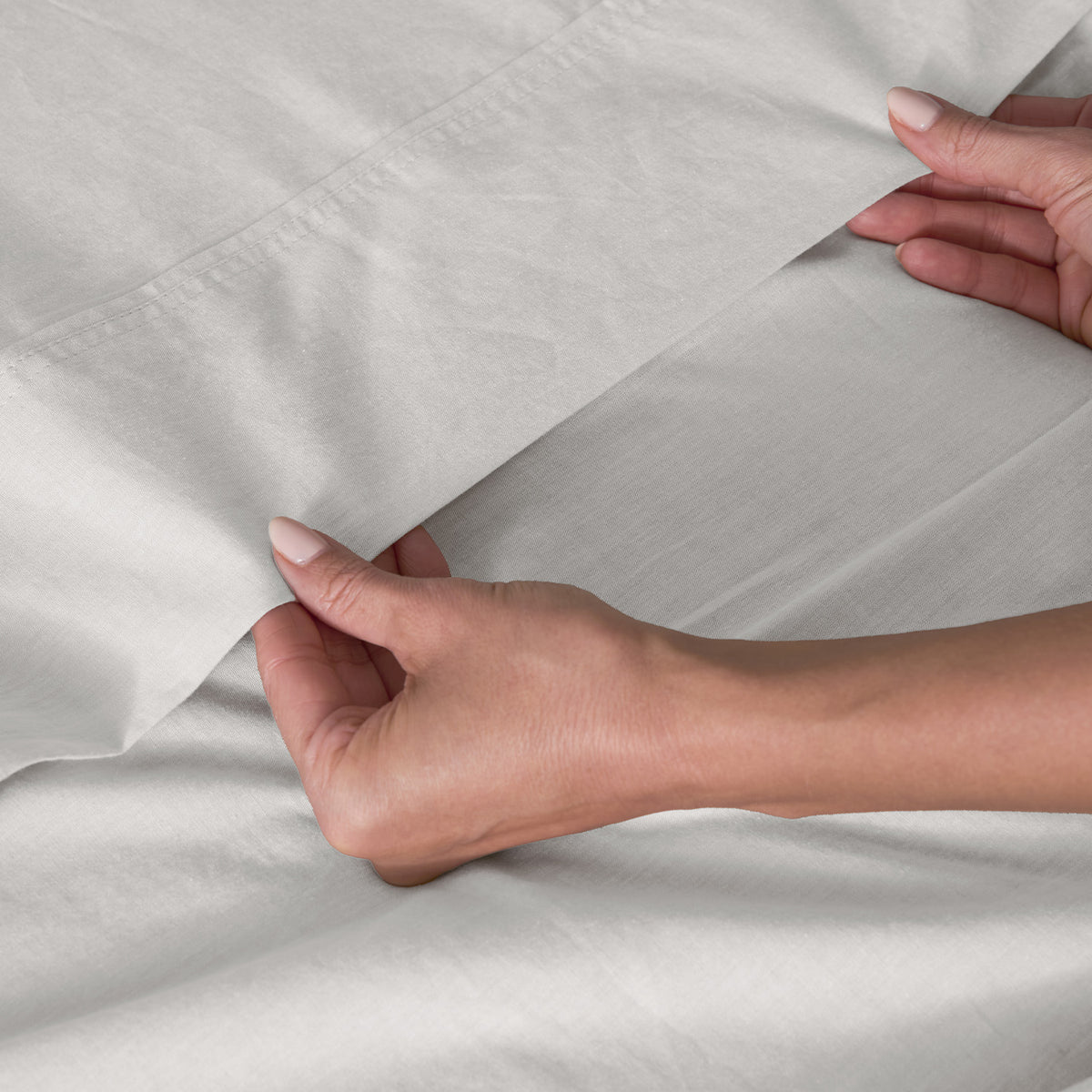 Close-up of a person's hands holding  an ivory sheet.