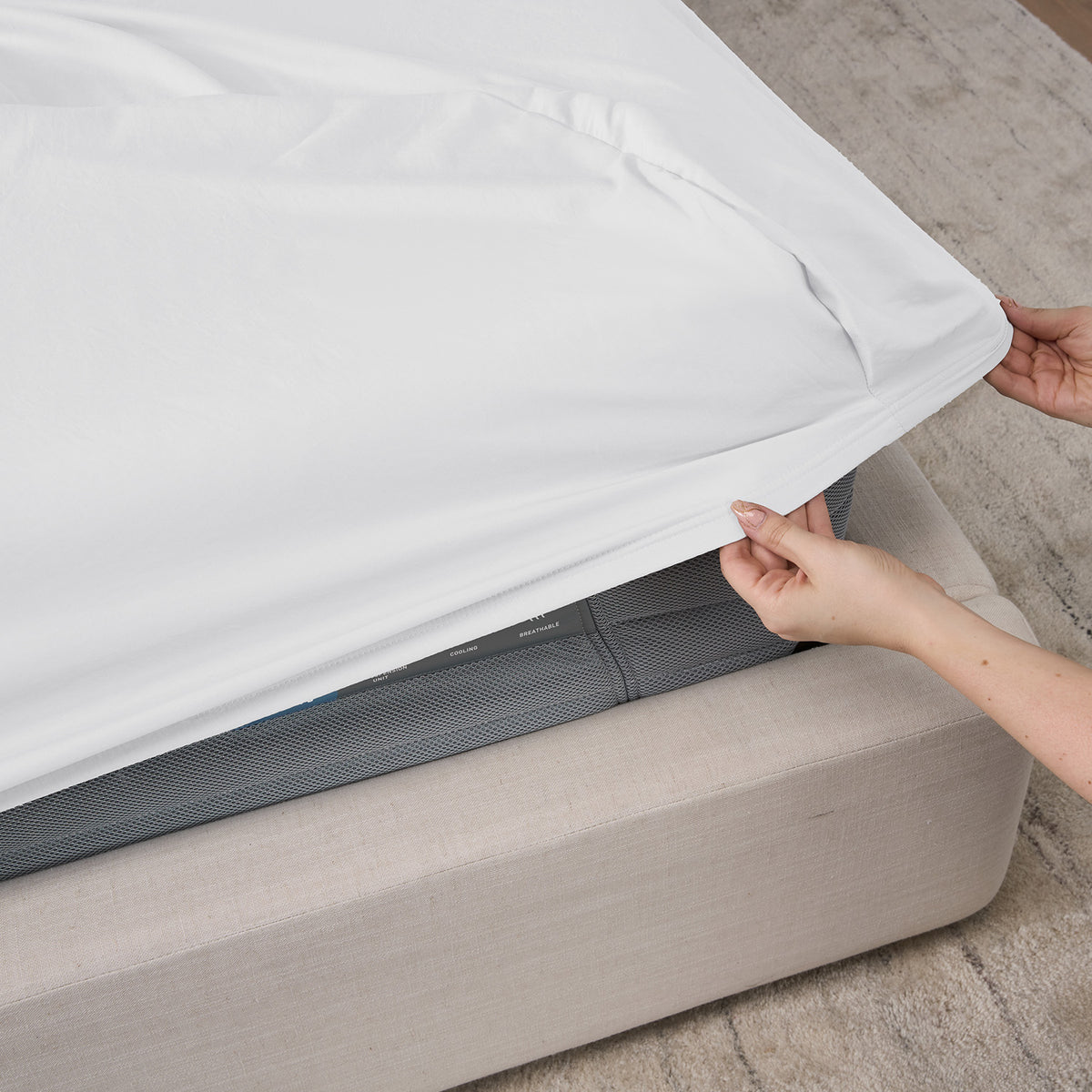 A woman putting an essential fitted sheet on a mattress.