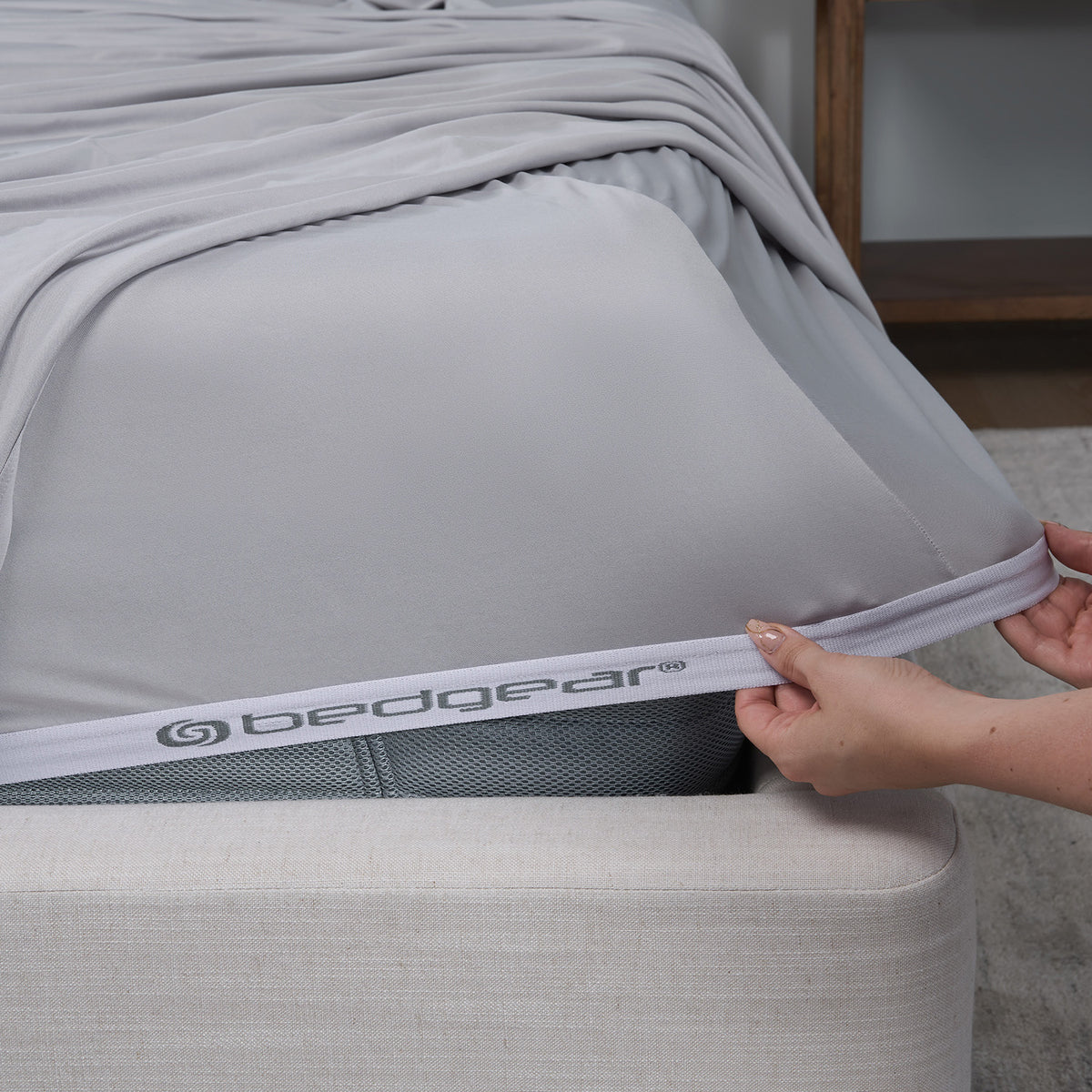 An image of a woman putting a grey fitted VerTex sheet on a mattress.