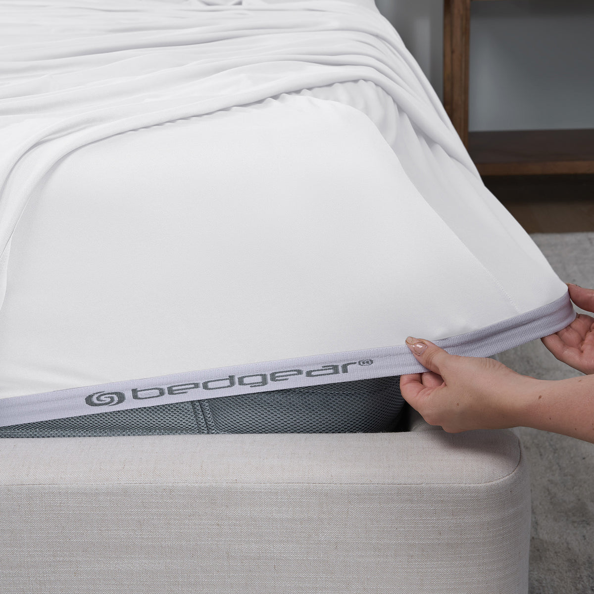 An image of a woman pulling BEDGEAR VerTex sheets over a mattress.
