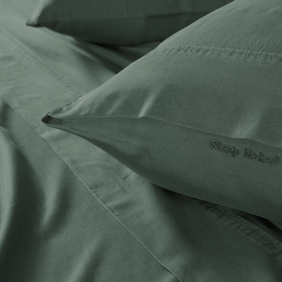Close-up of matching sheets and pillow  cases in a dark green color.