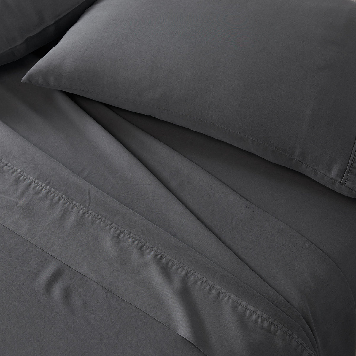 Dark gray bedding set including a pillowcase and sheet with visible hemstitching details.