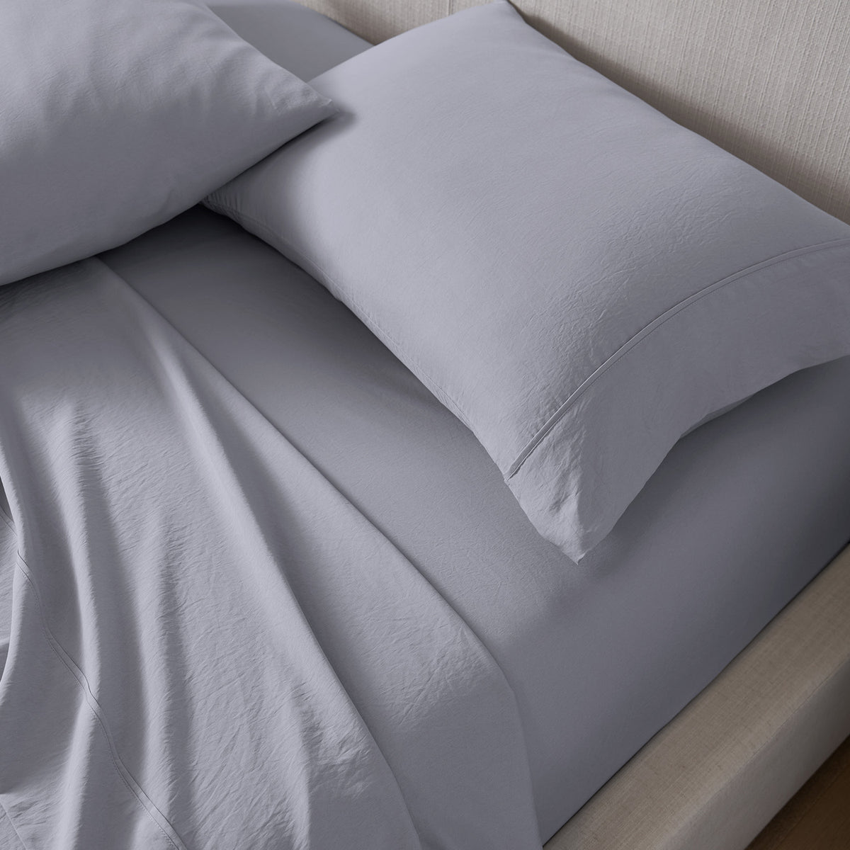 Two pillows next to each other on a mattress.