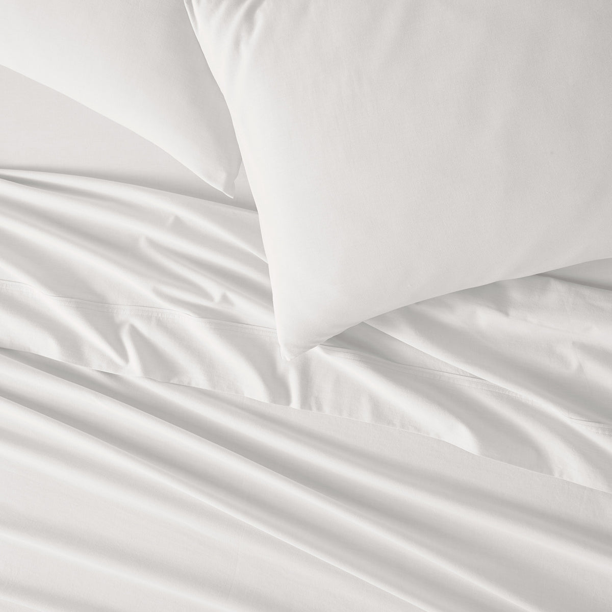 Ivory bed sheets and pillowcases close up.