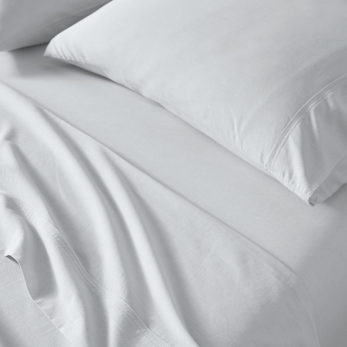 Light Grey bed sheets and a matching pillowcase on a bed, shown in a clean close-up view with soft folds and no visible branding.