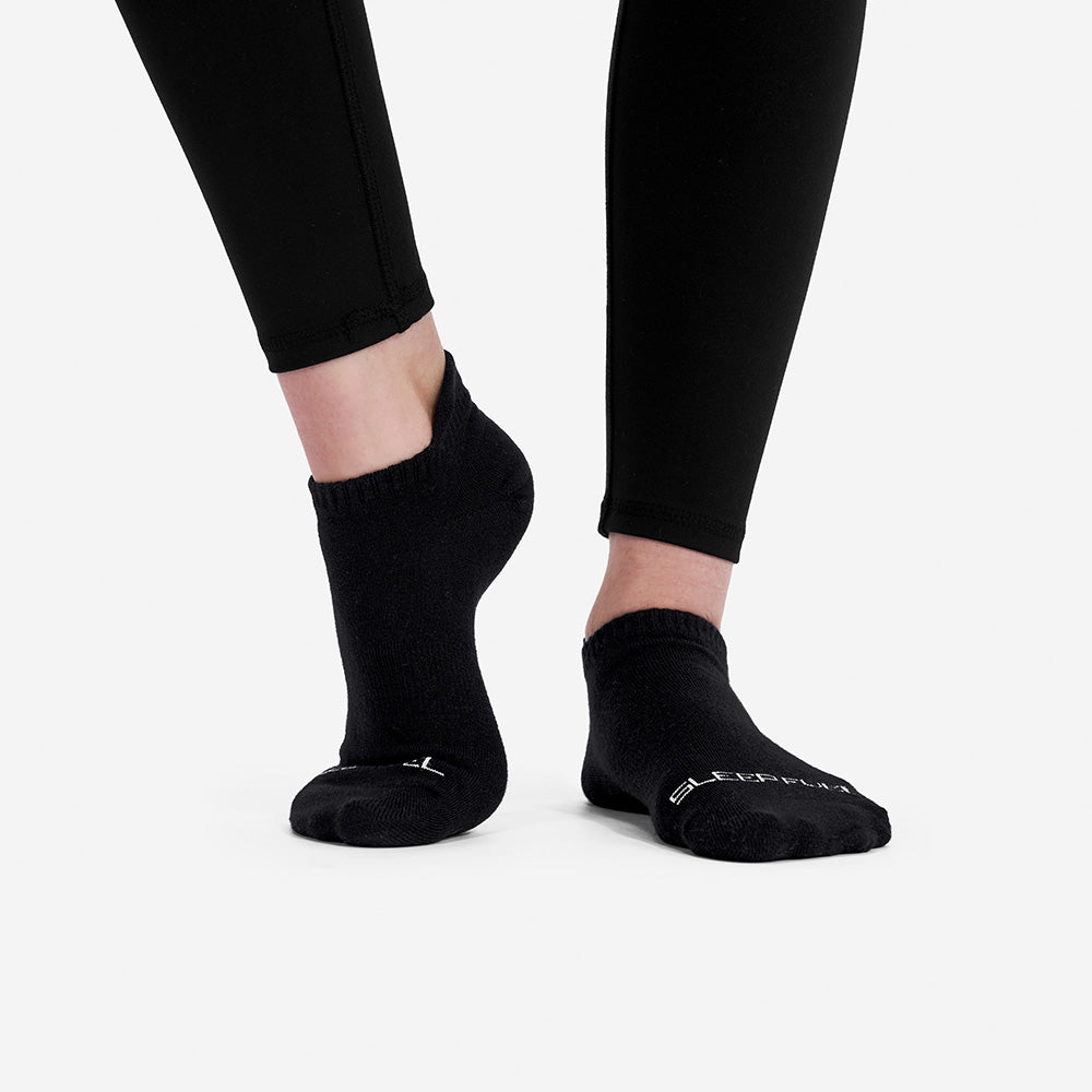 A woman wearing Sleep Fuel socks and leggings. 