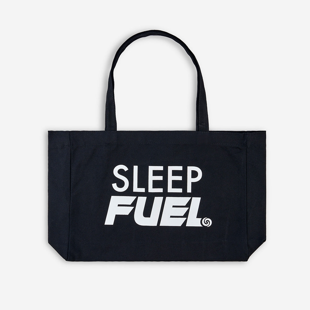 Sleep Fuel tote bag in front of a white background. 