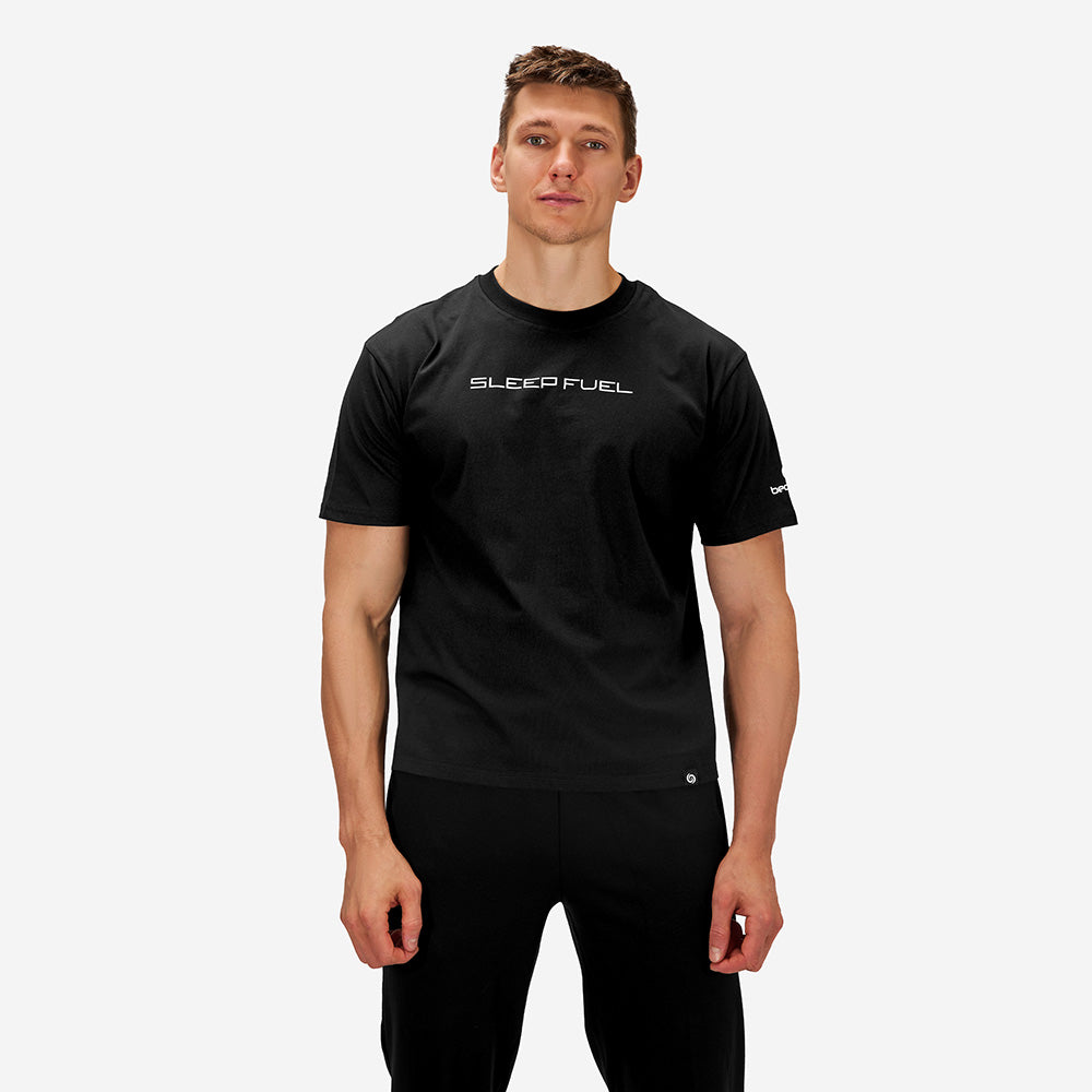 A man wearing a Sleep Fuel shirt in front of a white background. 