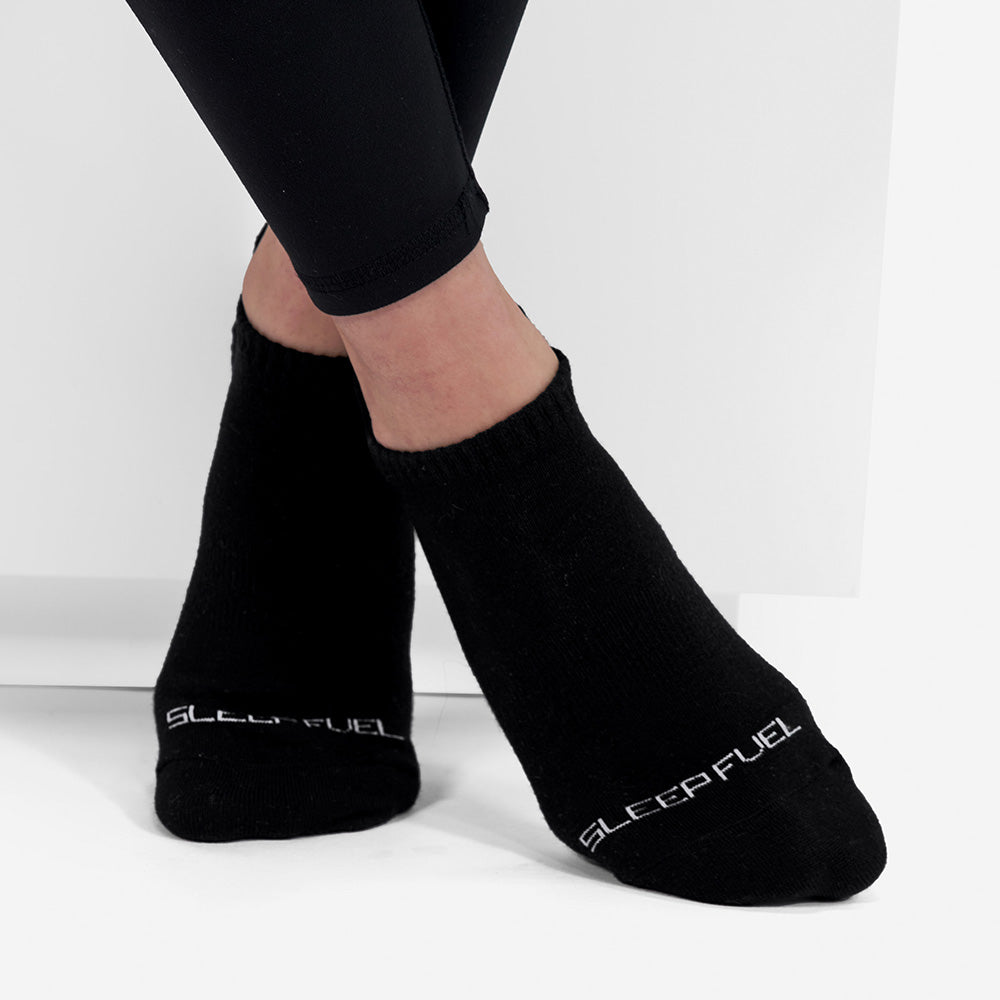 A woman wearing Sleep Fuel socks. 