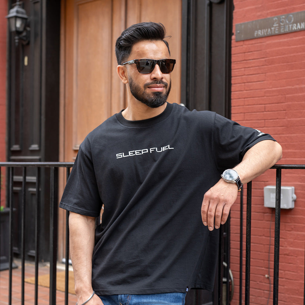 A man wearing a Sleep Fuel shirt. 