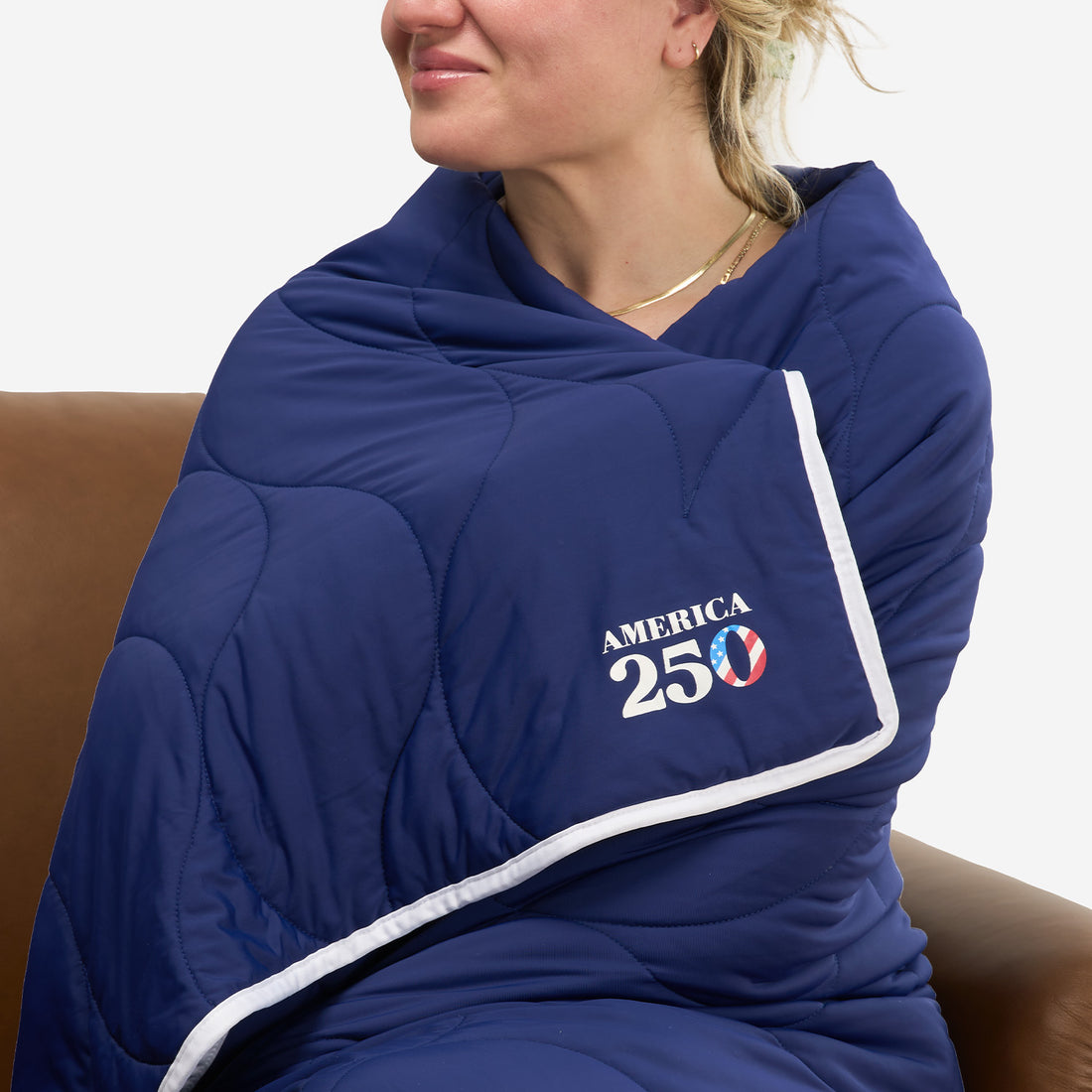 A photo of a woman wearing BEDGEAR's America 250 blanket. 