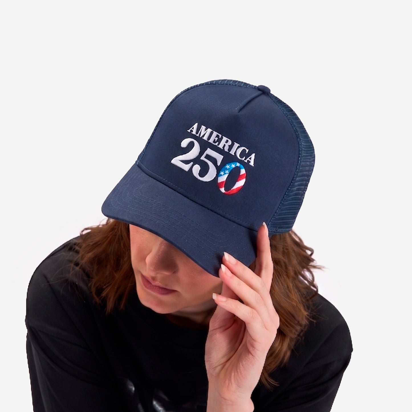 A woman modeling BEDGEAR's America 250 hat. 
