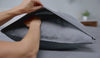 A woman covering a pillow with a secure fold pillowcase. 
